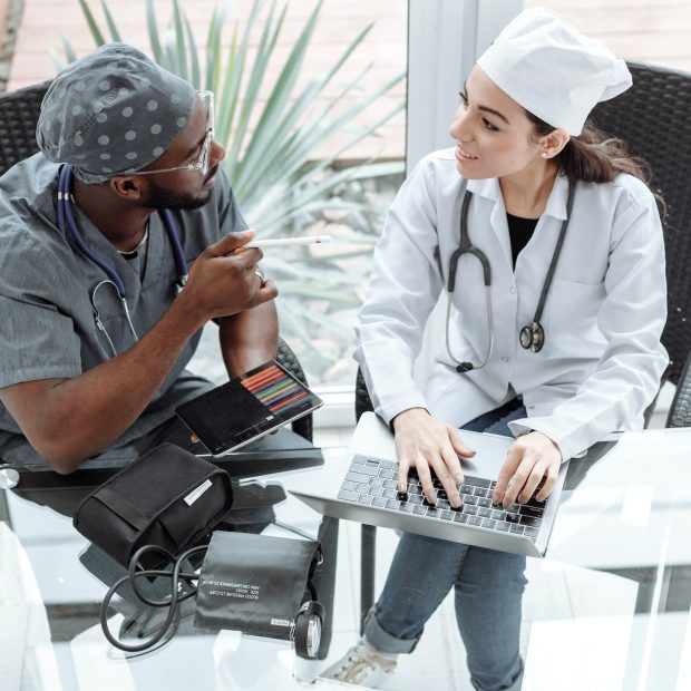 medical professionals sitting on a chair in front of a glass table while having a conversation