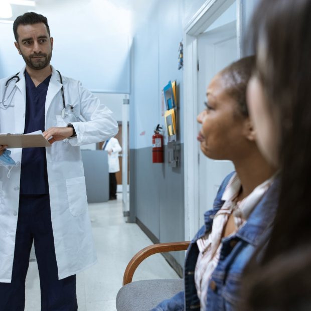 man in white medical scrub suit standing beside girl in blue denim jacket
